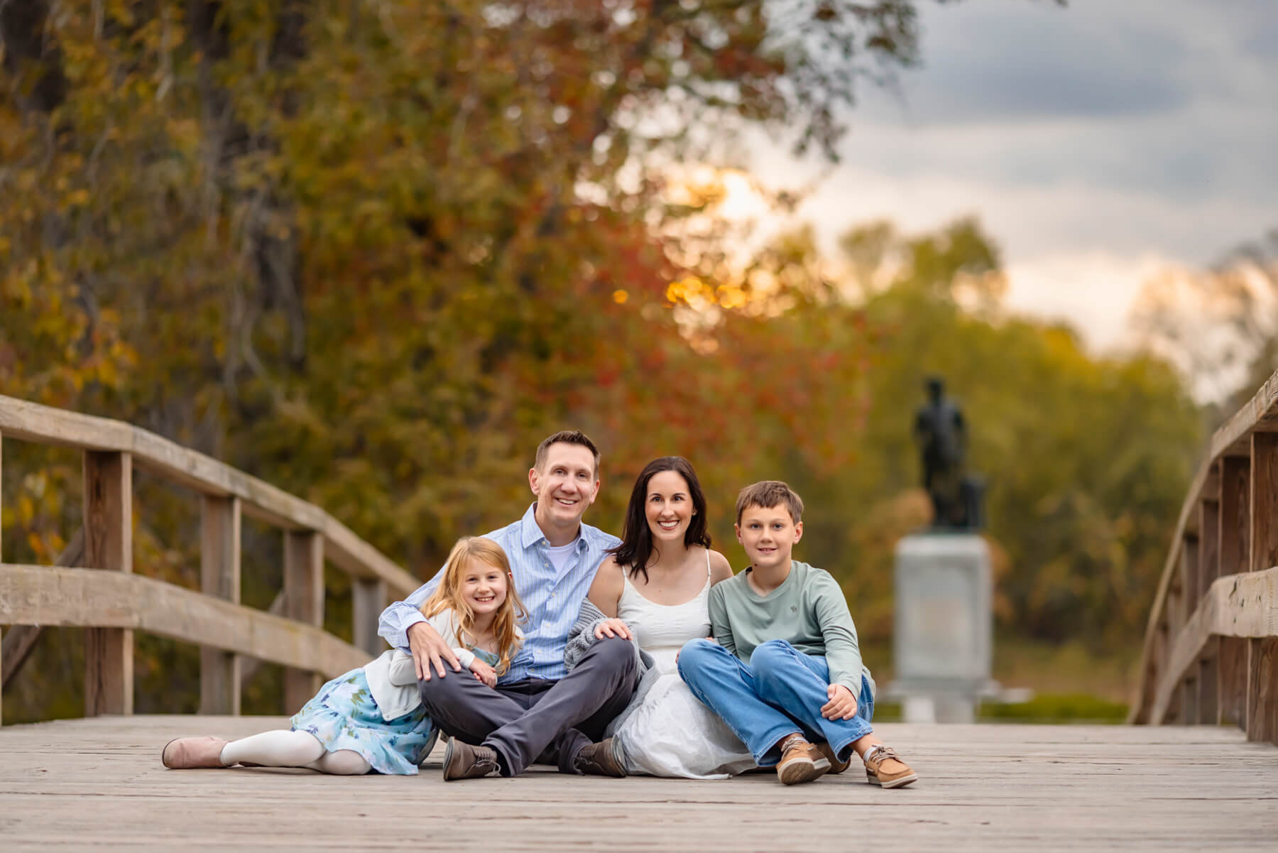 Fall family photo during golden hour sitting in the Old North Bridge in concord, MA