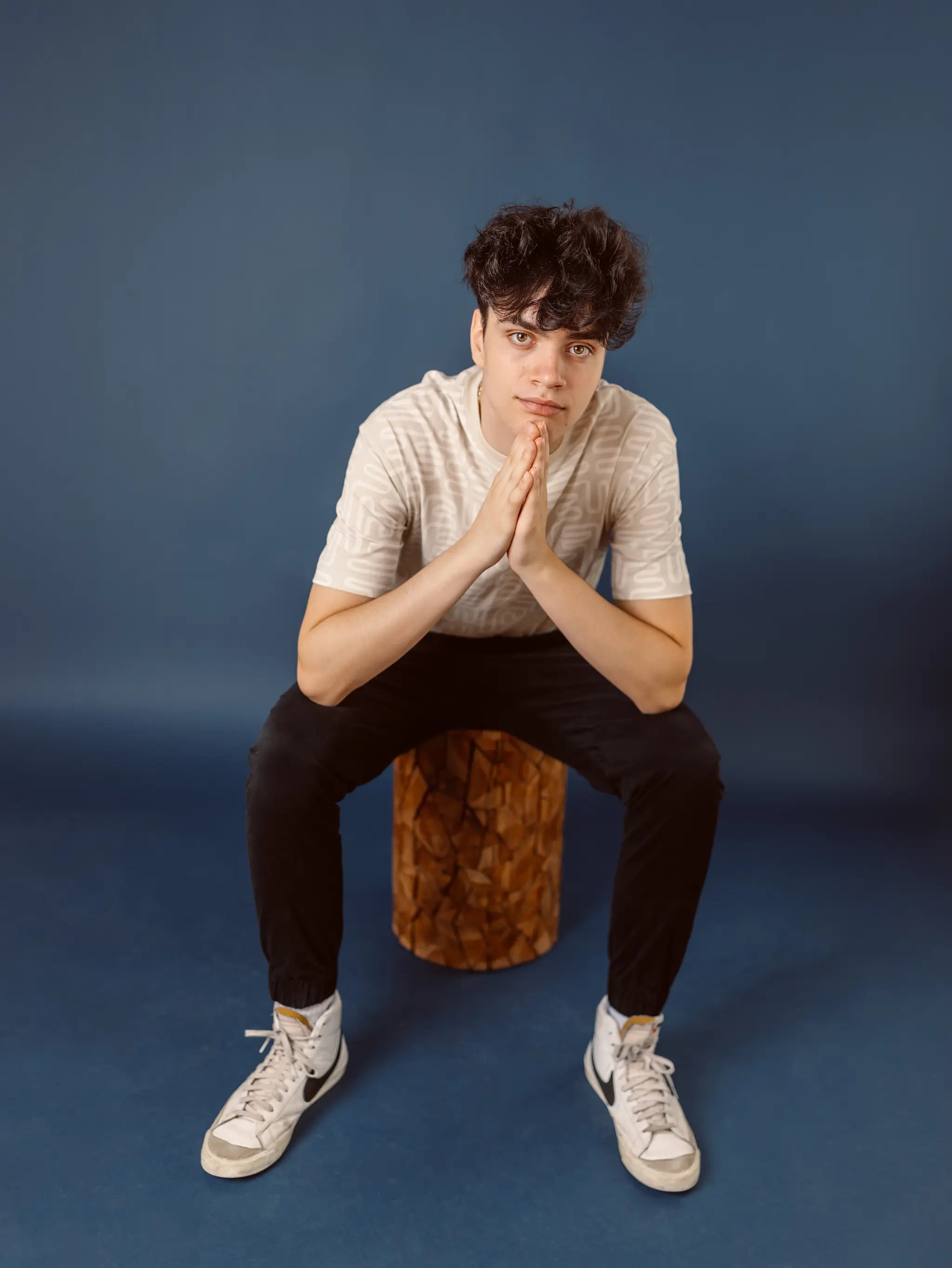 High school senior boy with hands together, at Photography Studio in Lexington.