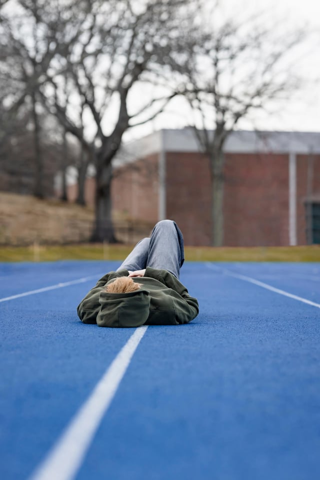 High school Senior trans boy in field track, at Lexington, Massachusetts