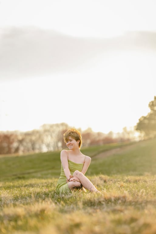 High School senior trans boy sitting on an spring field, at Lexington, MA