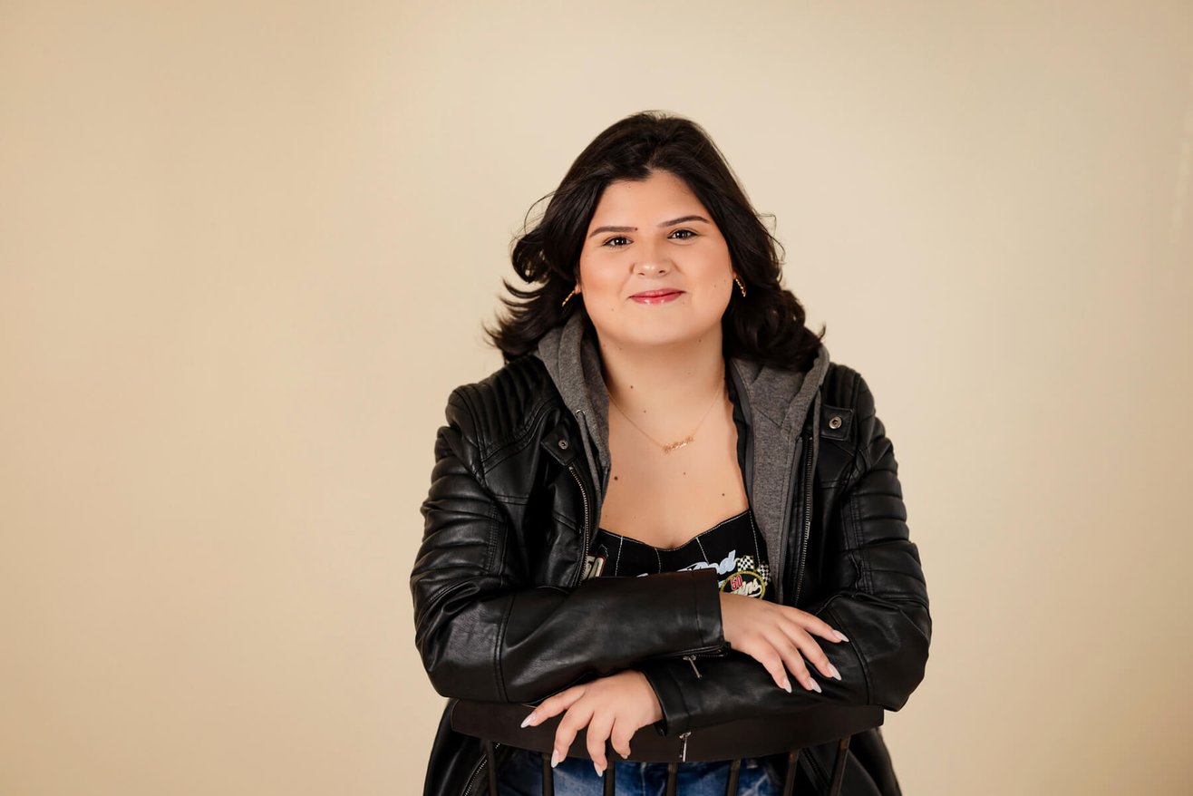 High School senior girl sitting on a chair, at the studio