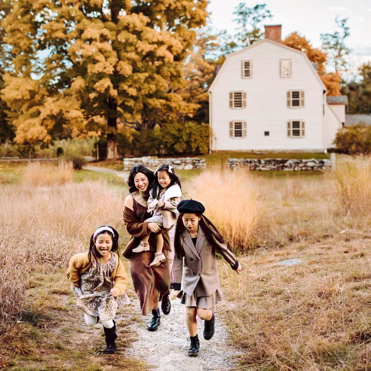 mom and kids running in tall grass during peak foliage in Boston