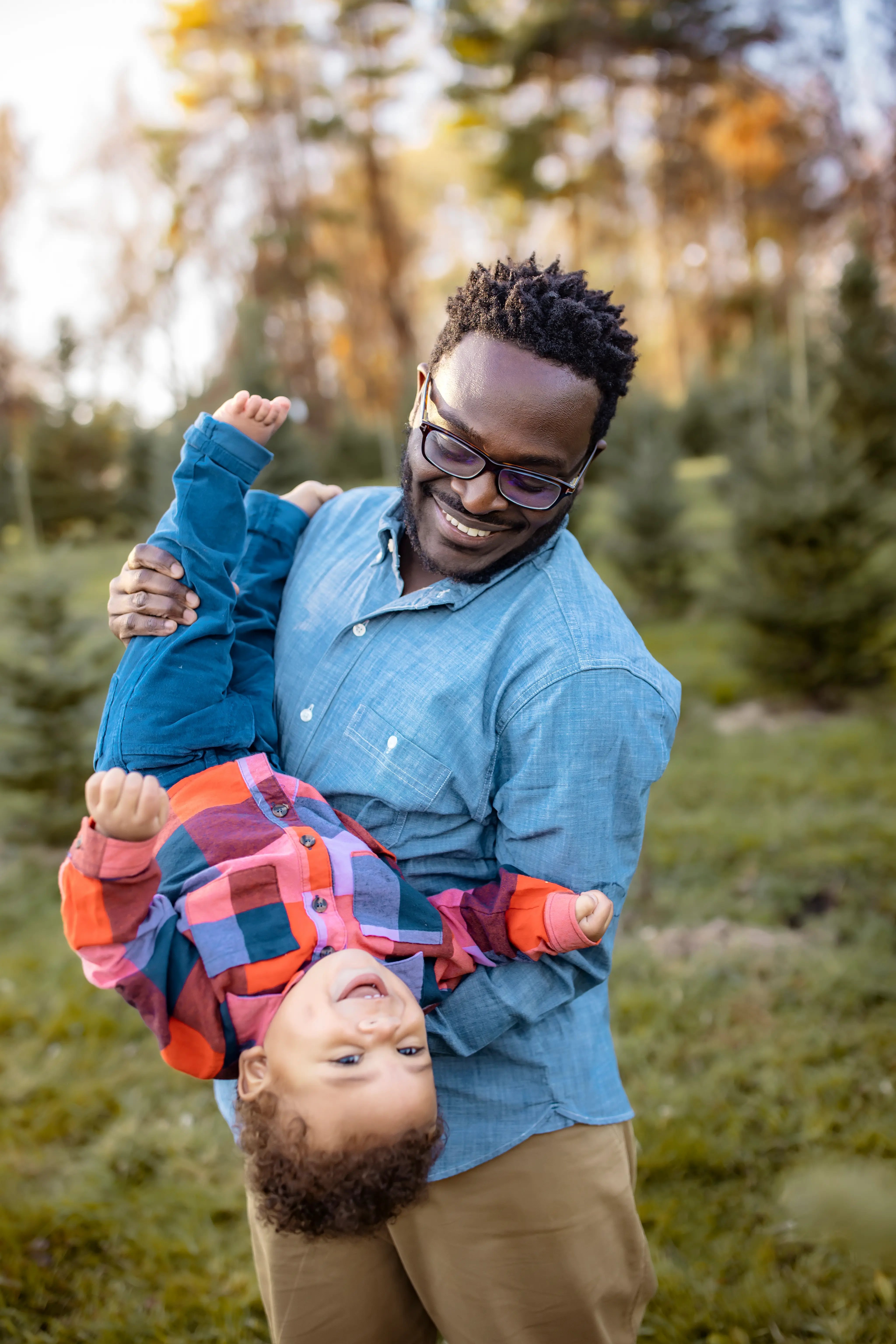 fall_father holds son upside down - tree farm photography
