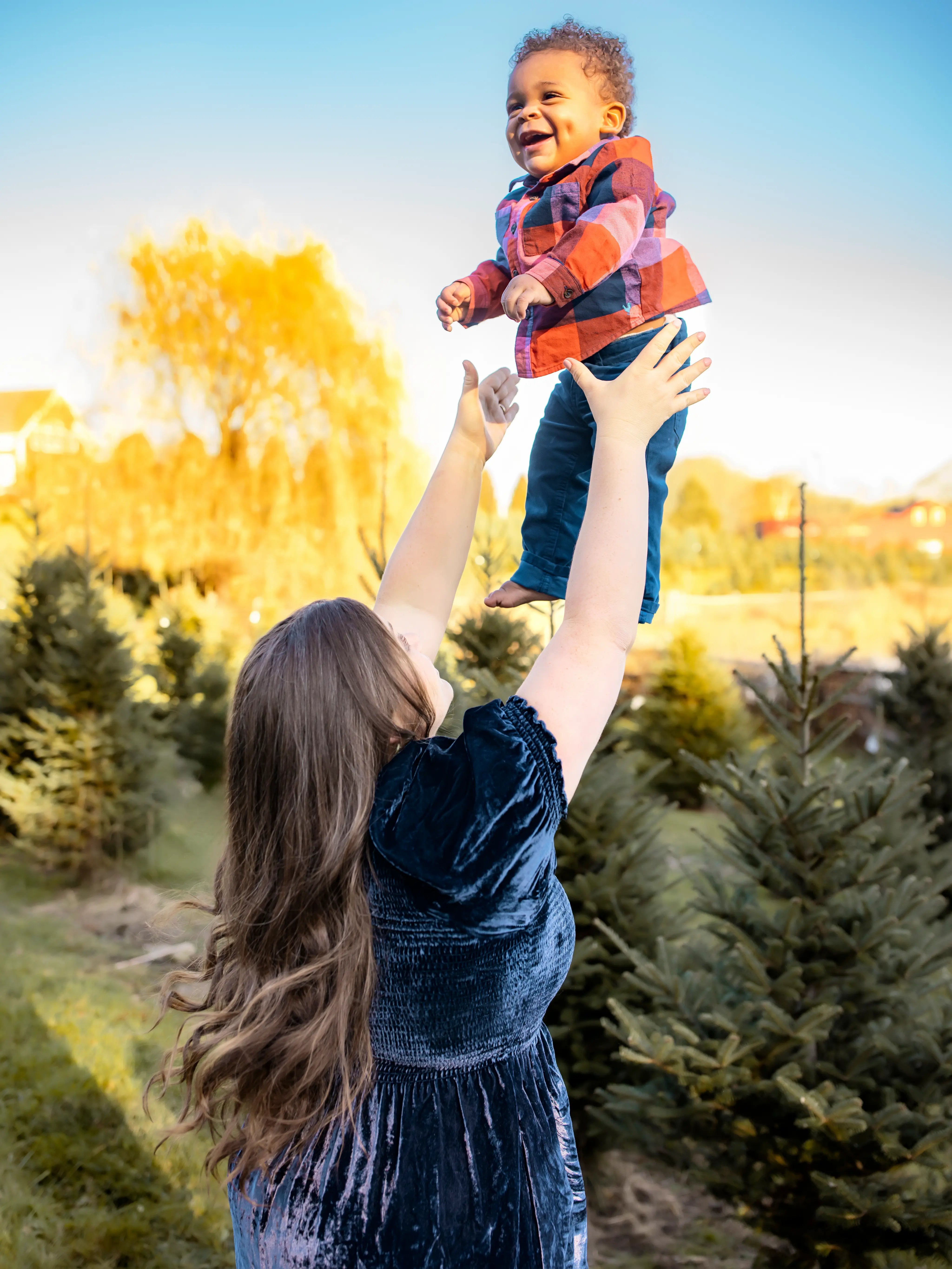 fall_mother lifting up baby - tree farm photography